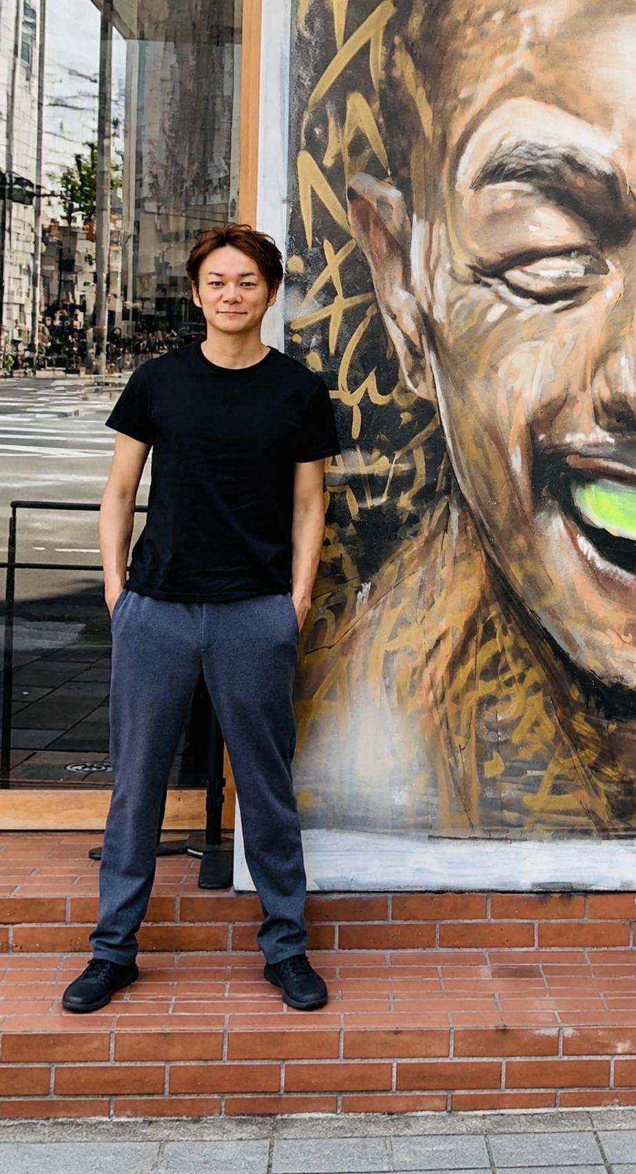 壁画の前に立つ平井拓郎さん